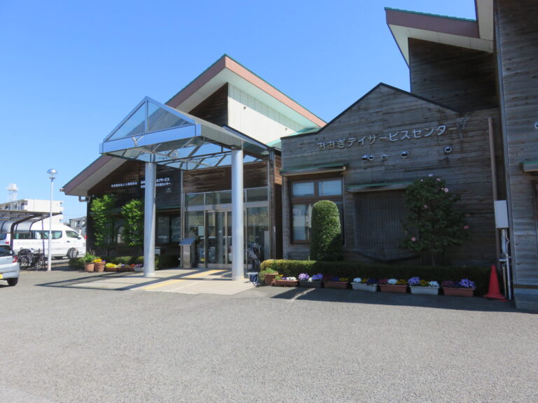 介護施設の玄関・車寄せ。モダンな建築、ポーチ、植栽が整えられた入口